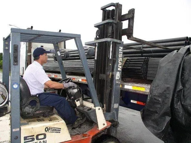 A man is driving a forklift with the number 50 on it.