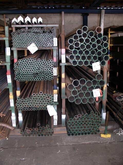 A bunch of metal pipes are stacked on shelves.