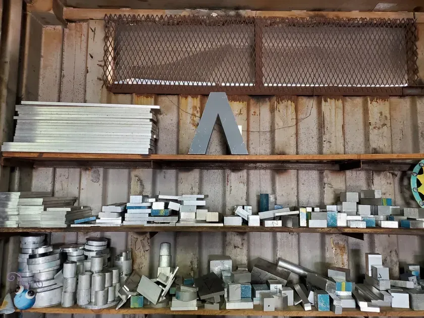 A shelf filled with a variety of metal pieces.