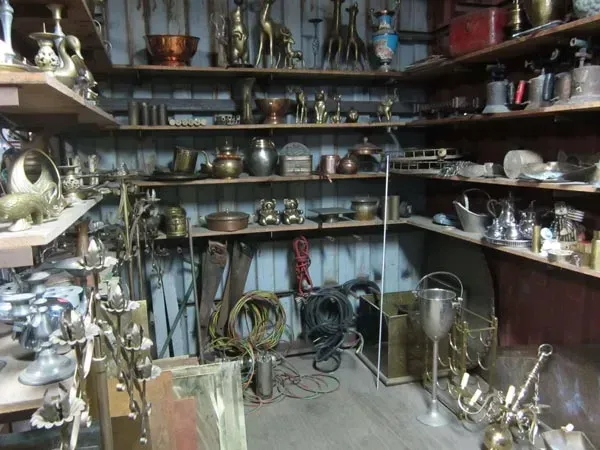 A room filled with shelves filled with vases and candles.
