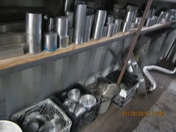 A bunch of metal pipes are sitting on a shelf in a room.