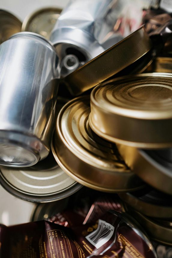 A pile of cans and a bag of candy are stacked on top of each other.