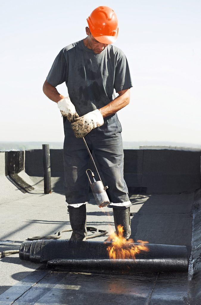 Un homme portant un casque travaille sur un toit