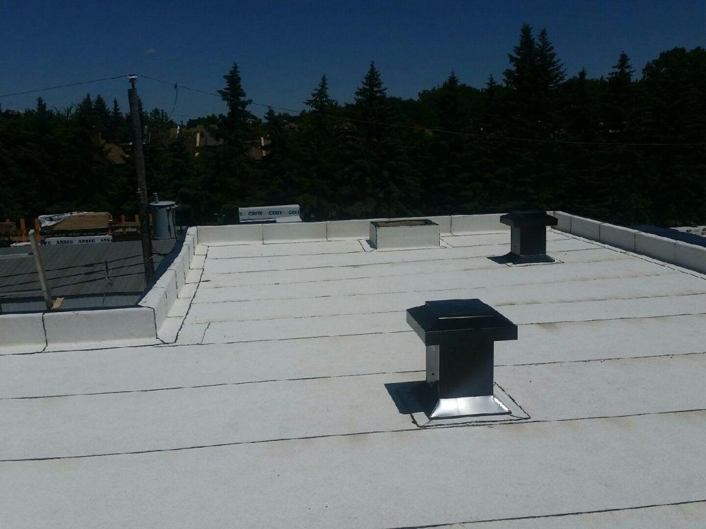 Un toit blanc avec quelques cheminées dessus