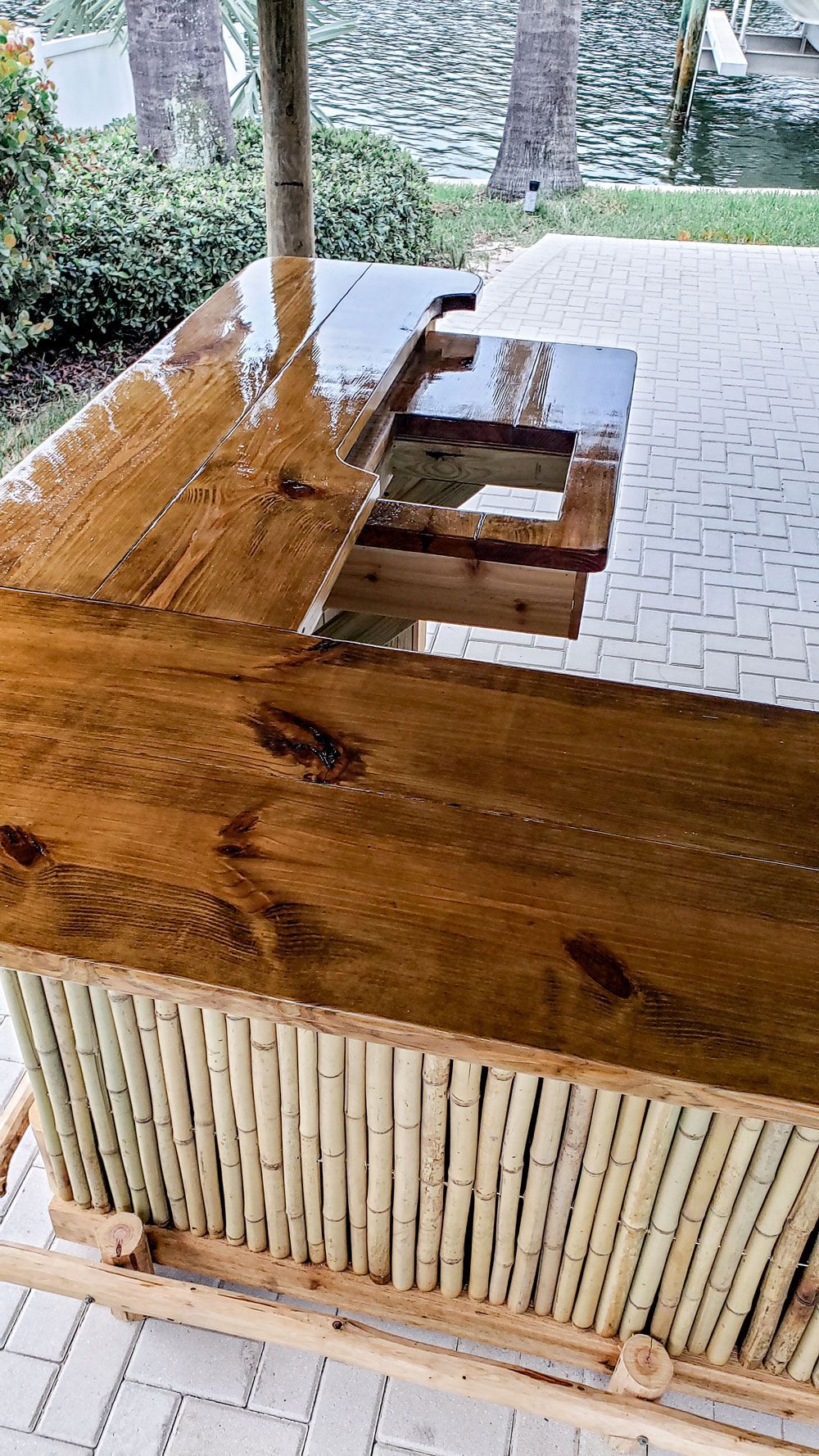 Outdoor bar with a bamboo base and wood countertop with recessed areas.