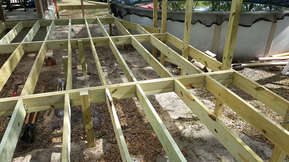 Wooden deck frame under construction outdoors.