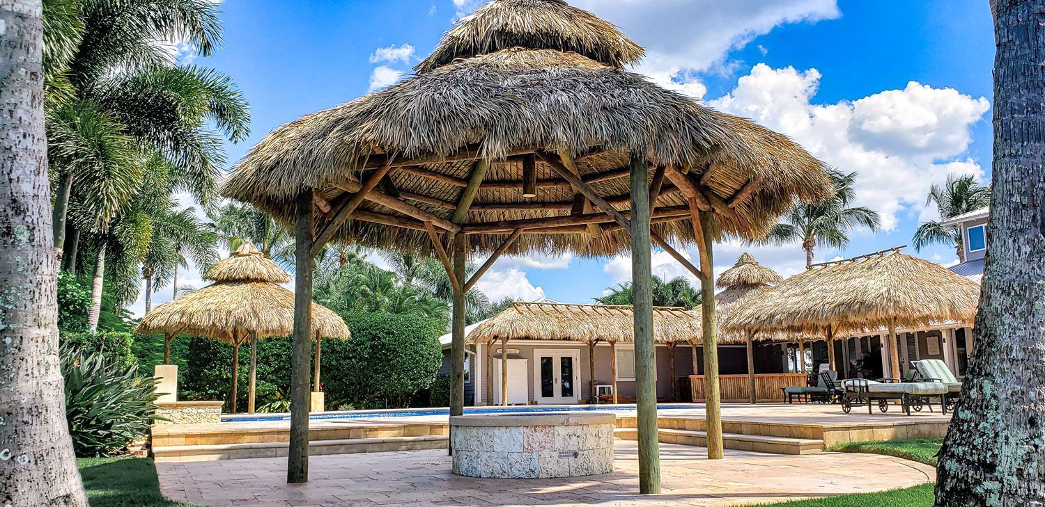 Tiled roof huts on a tropical property. Wooden posts and straw roofs on a sunny day.