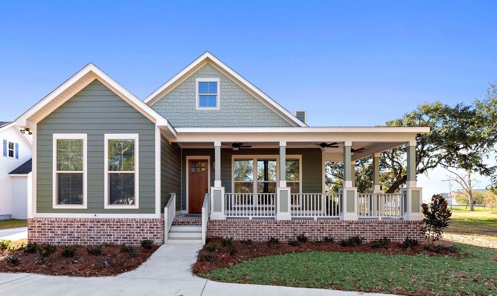 Green and brick house with front porch and walkway.