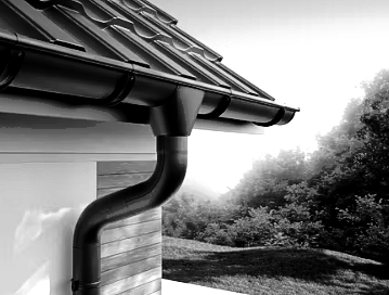 Black rain gutter and downspout on a house roof, with trees in the background.