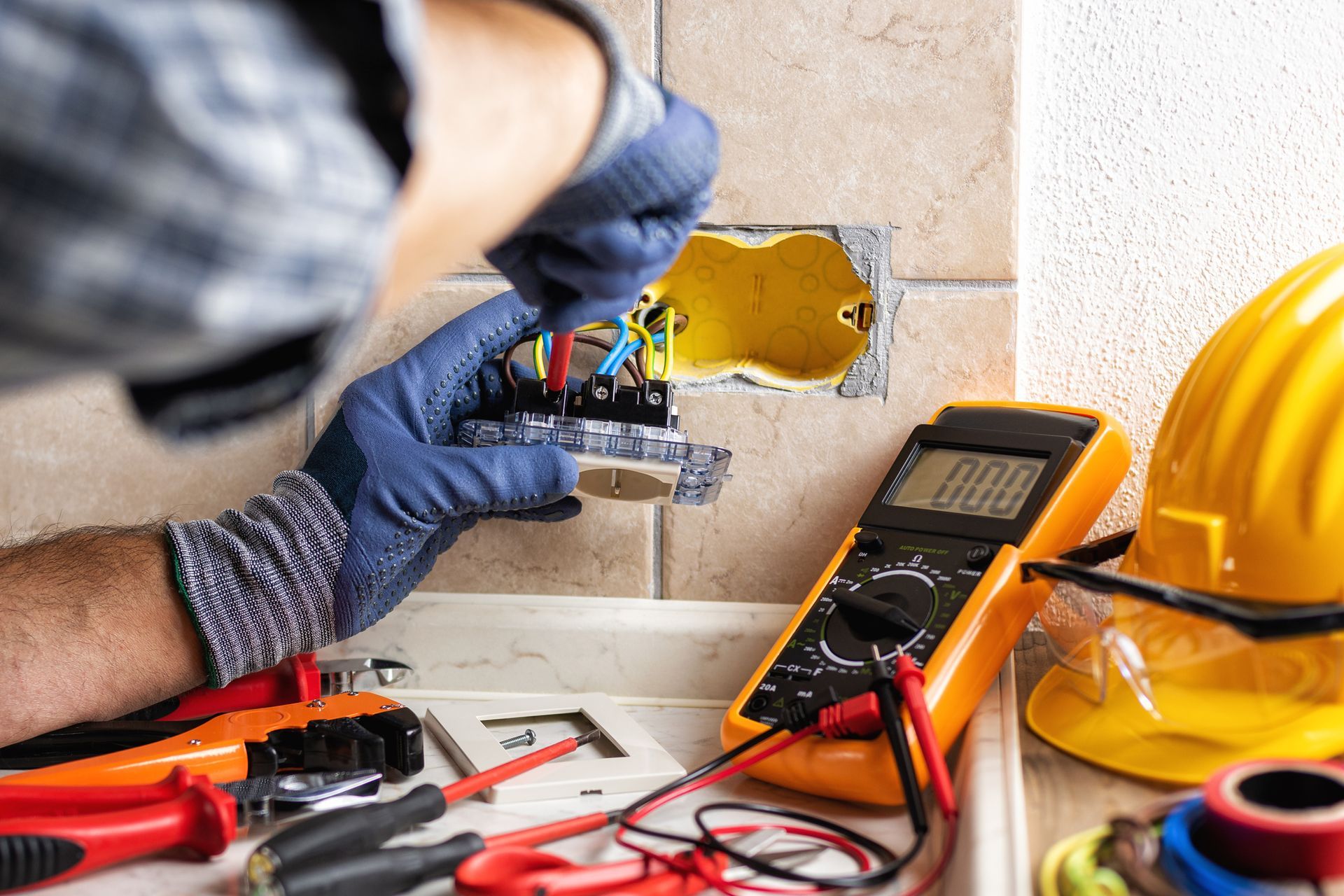 Electrician at work with safety equipment on a residential electrical system. Electricity