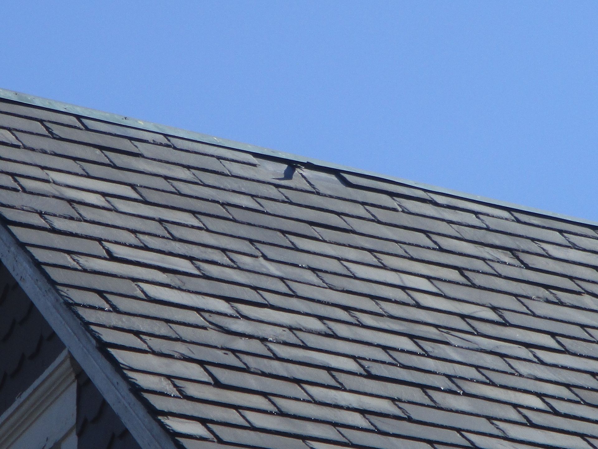 An aerial view of a wooden house with a black roof.