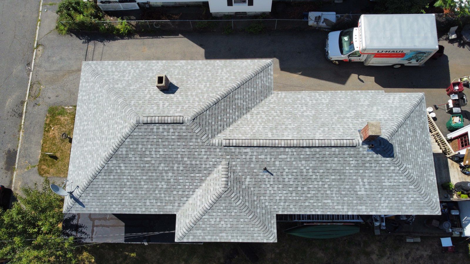 An aerial view of a large white house with a brown roof