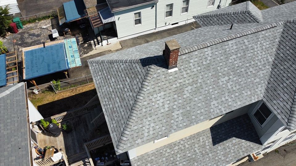 An aerial view of a wooden house with a black roof.