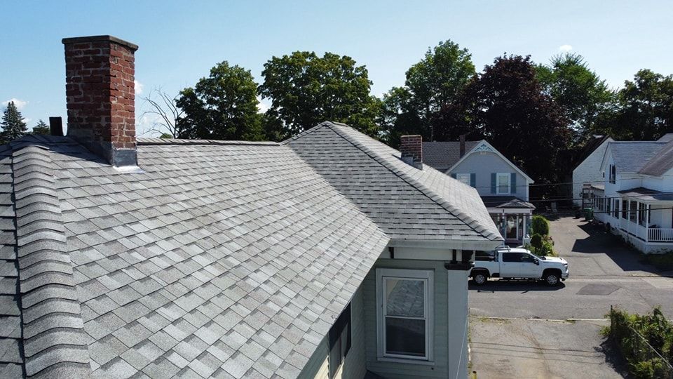 An aerial view of a wooden house with a black roof.