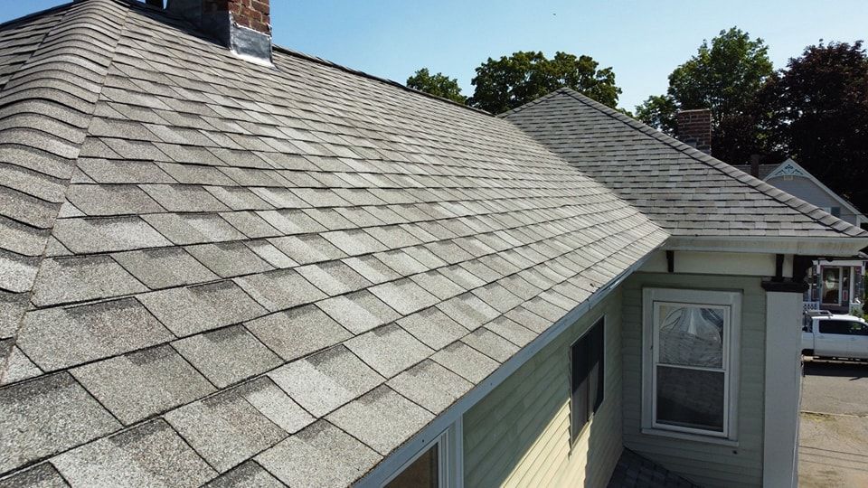 An aerial view of a wooden house with a black roof.