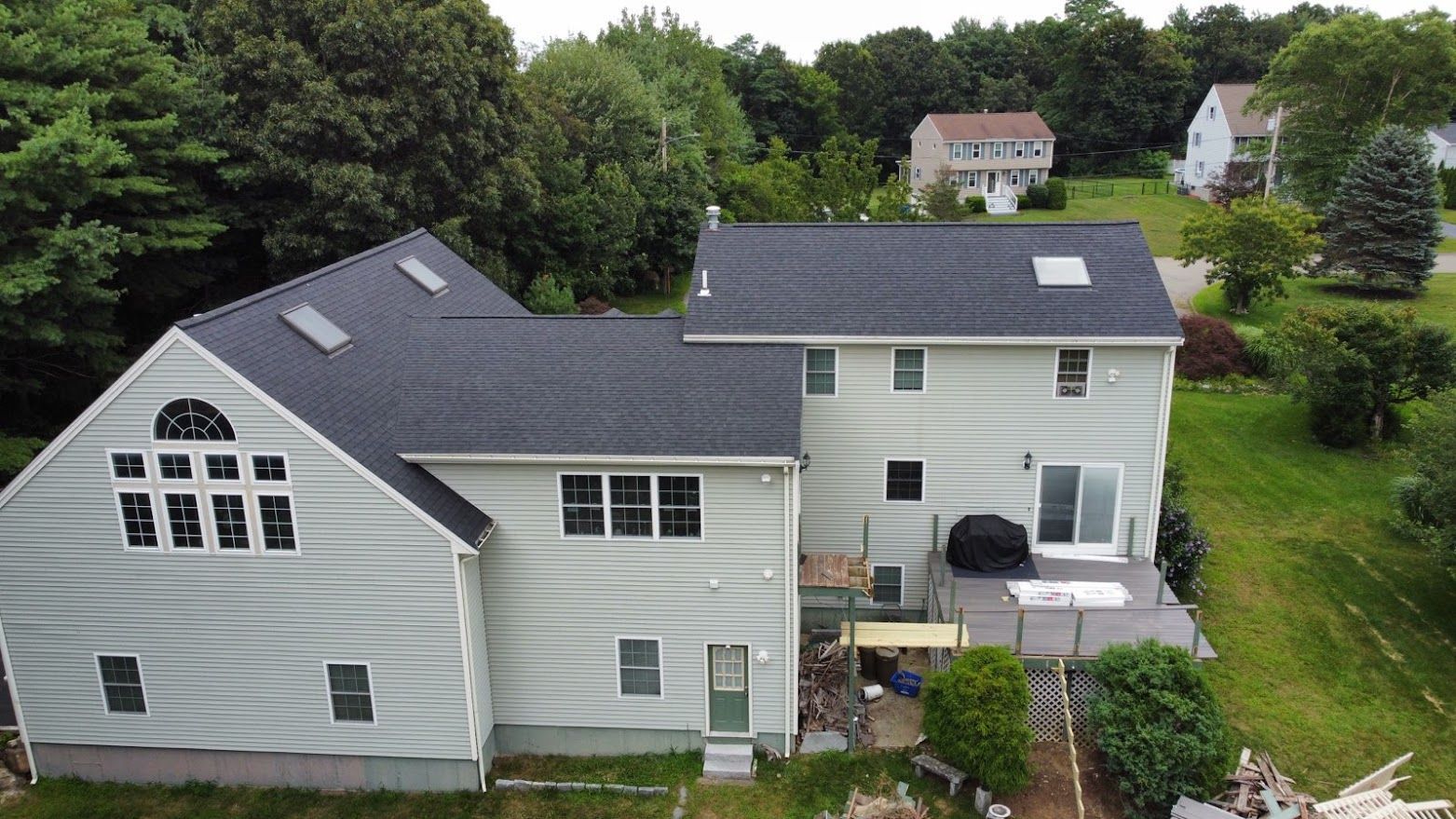 An aerial view of a wooden house with a black roof.