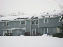 a row of houses with snow on the roofs