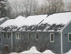 a row of houses with snow on the roofs