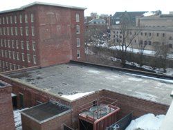 a large brick building with a roof that is covered in snow .