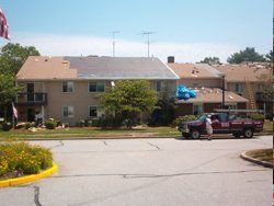 a red truck is parked in front of a house with balloons on the roof .