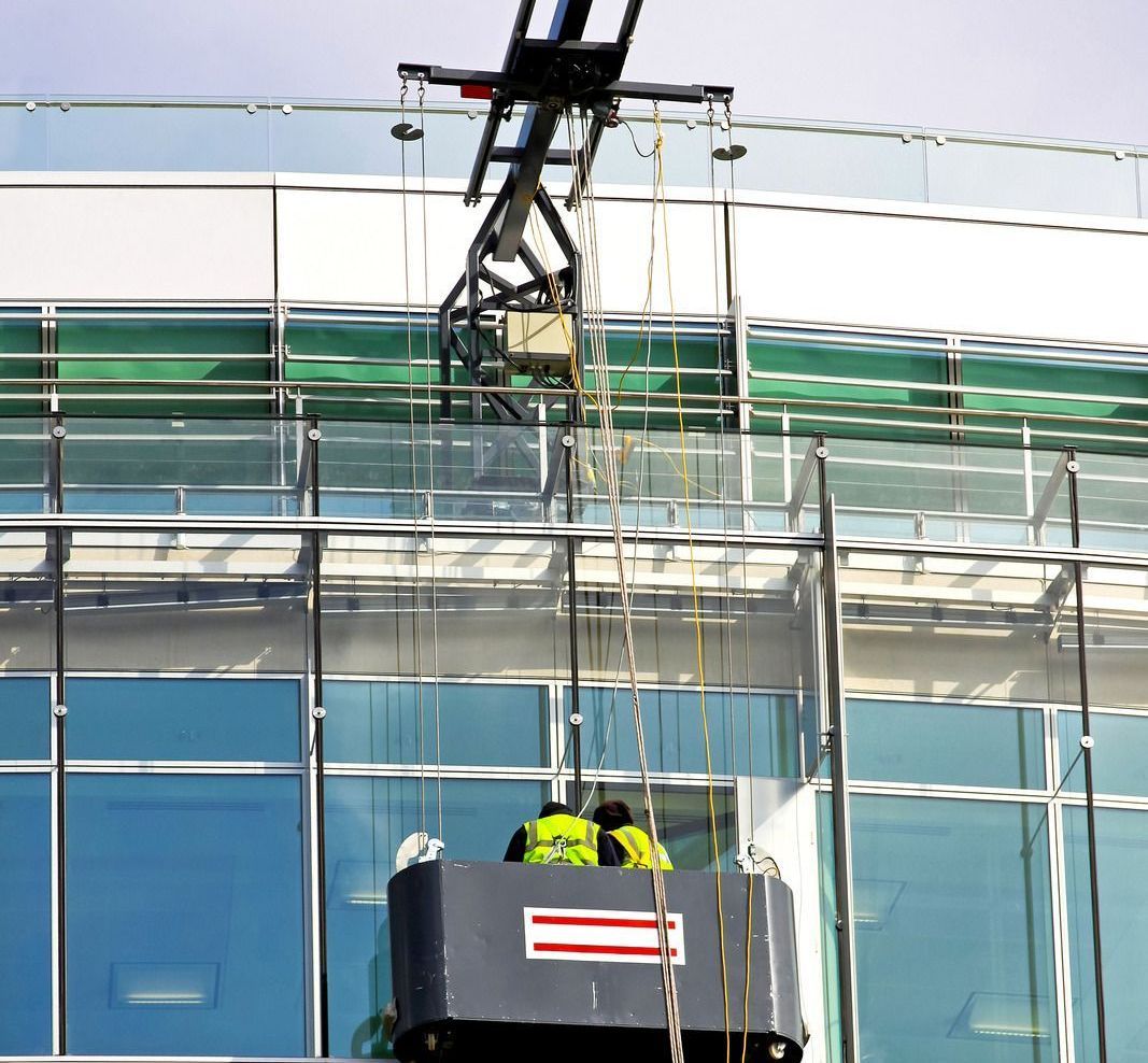 A man is in a bucket on top of a building