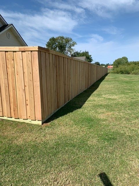 A wooden fence is sitting in the middle of a lush green field.