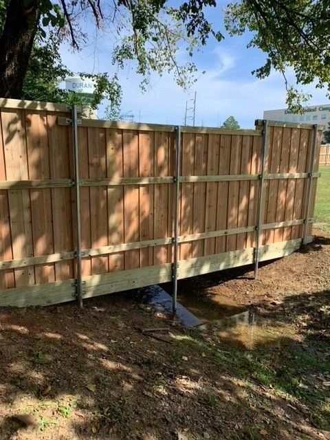 A wooden fence is sitting in the middle of a field.