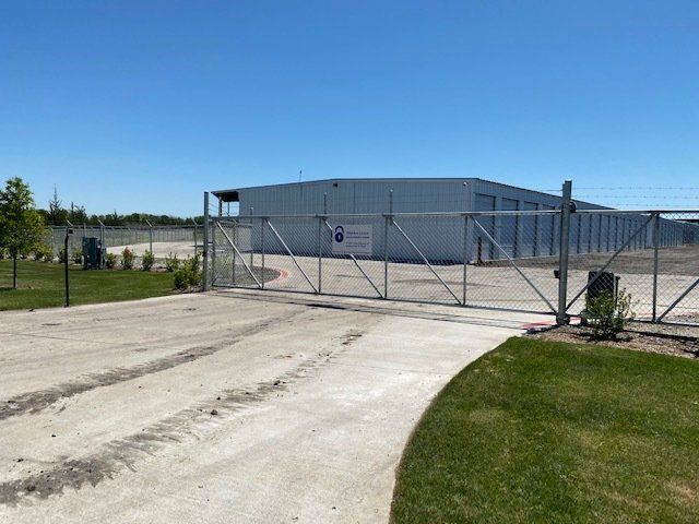 A large white building with a sliding gate in front of it.