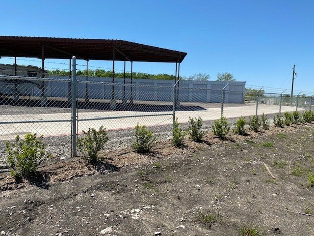 A chain link fence surrounds a building with a canopy