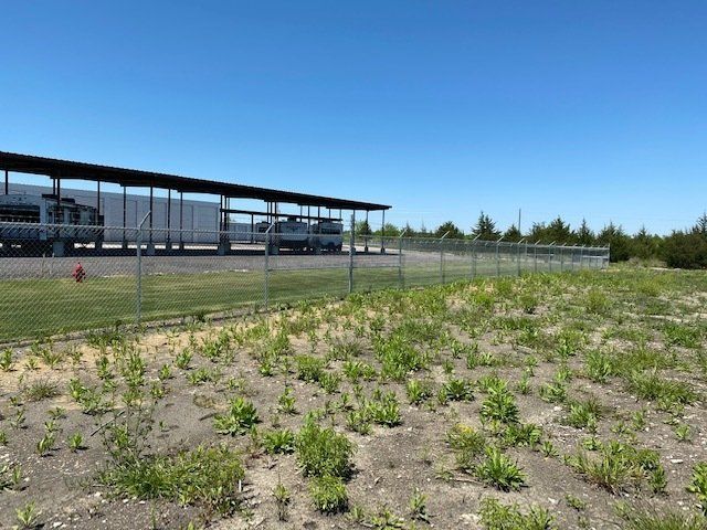 A fenced in area with a truck parked in the background
