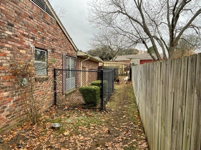 A brick house with a wooden fence in front of it.