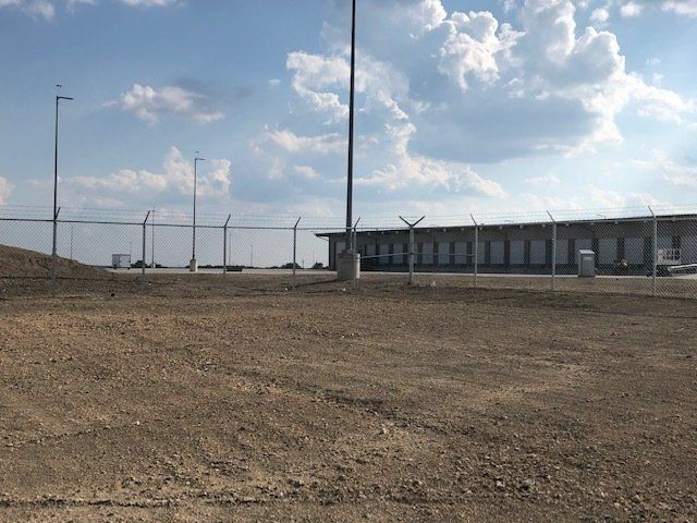 A fenced in area with a building in the background