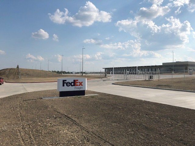 A fedex sign is on the side of the road