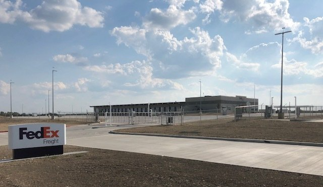 A fedex sign is in front of a large building