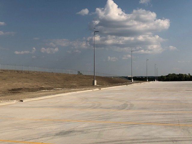 An empty parking lot with a fence in the background