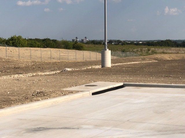 A street light is sitting in the middle of a dirt field.