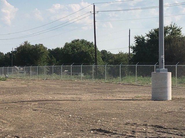 A fenced in area with a pole in the middle