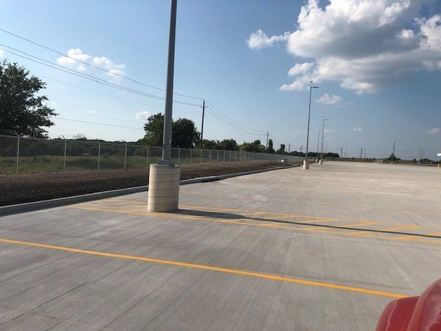 An empty parking lot with a fence in the background