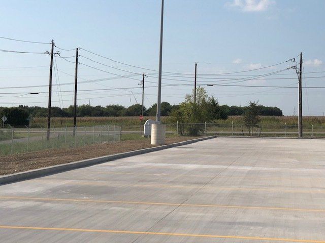 A parking lot with a lot of power lines in the background