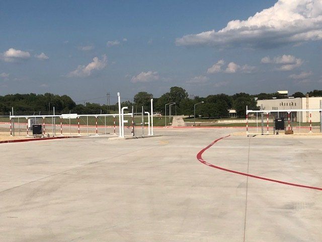 A large empty parking lot with a building in the background