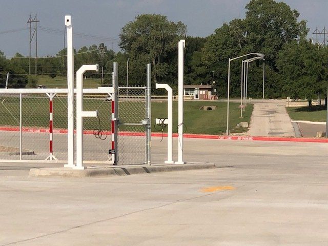 A parking lot with a fence and a sign that says ' fuel ' on it