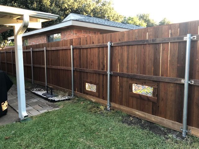 A wooden fence is in the backyard of a house.