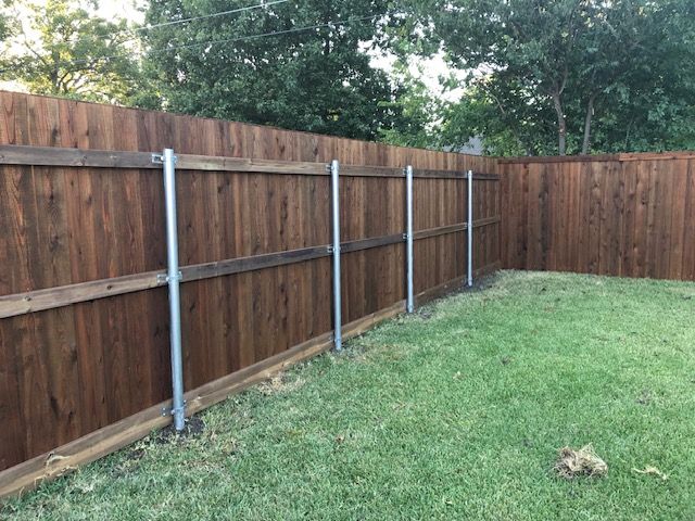 A wooden fence is sitting on top of a lush green lawn.