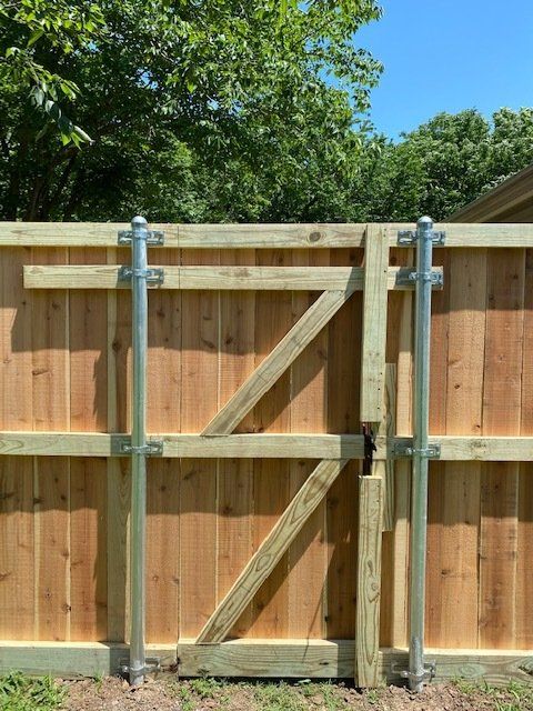 A wooden fence with a metal gate attached to it