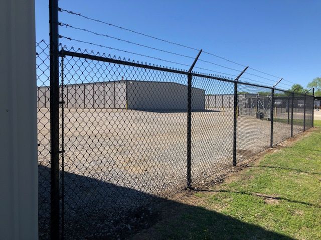 A chain link fence with barbed wire on top of it
