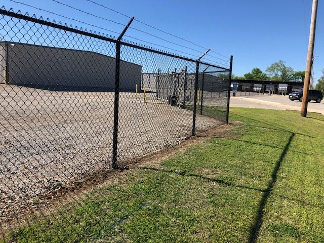A chain link fence with barbed wire on top of it