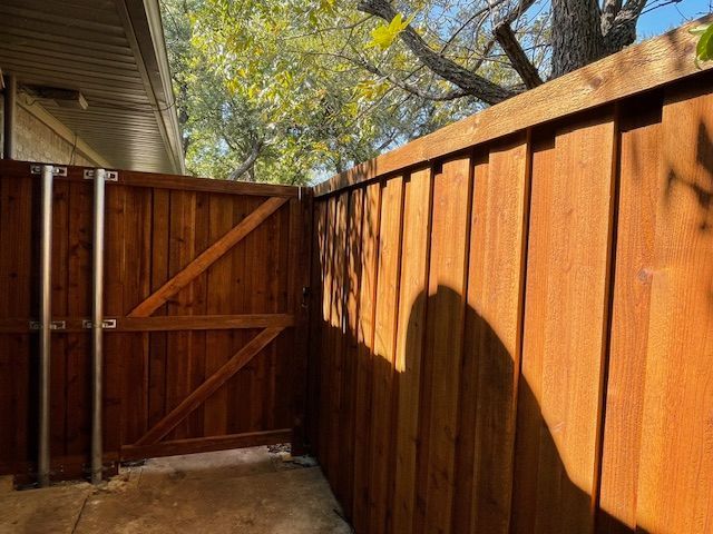 A wooden fence with a gate in the backyard of a house.