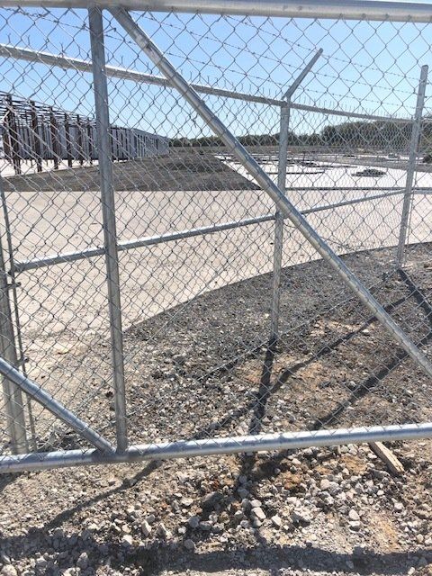 A chain link fence with a gate that is open
