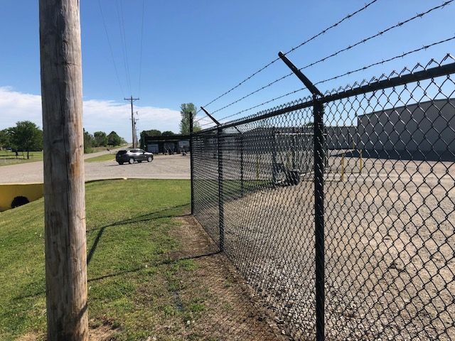 A chain link fence with barbed wire on top of it