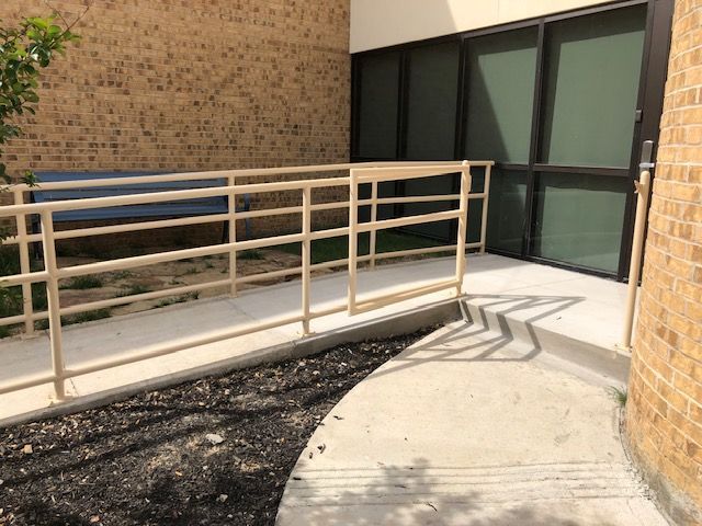 There is a ramp leading to a building with a railing.